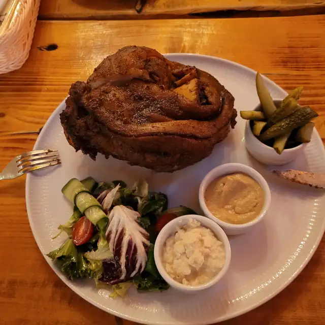 Pieczona golonka z ogórkami, surówką, chrzanem i musztardą