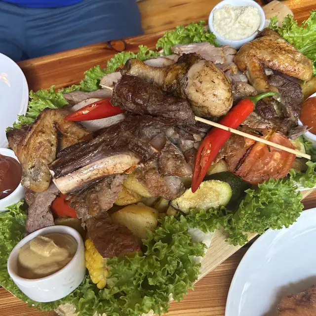 Deska grillowanych mięs z papryczkami, warzywami i sosami